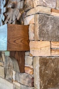 Closeup of stone fireplace with wood mantle